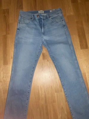 Ljusblå skinny jeans från Wrangler - Säljer ett par ljusblå skinny jeans från Wrangler med klassisk femficksdesign och hög midja. Jeansen har bälteshällor och dragkedjegylf. Perfekta till en avslappnad streetstyle-look. Möts i stockholm 