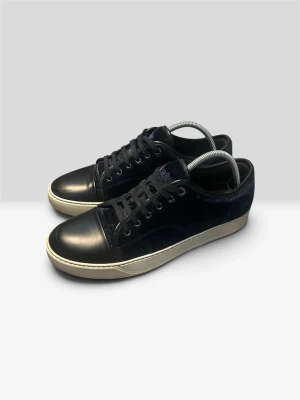 Mörkblå Lanvins - Stilrena svarta sneakers med ovandel i mocka och tåparti i slätt läder. Skorna har vita sulor och svarta skosnören. Perfekta för dig som gillar en clean och klassisk look med en twist av olika material.