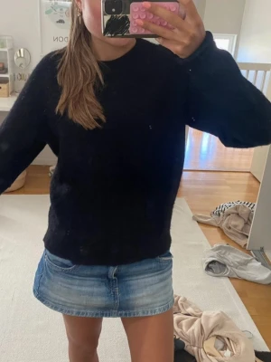 Svart oversized stickad tröja - En enkel svart stickad tröja med rund hals och långa ärmar. Tröjan har en avslappnad passform. Eventuellt lite nopprig men inget som syns när man bär tröjan och går lätt bort med noppermaskin😇