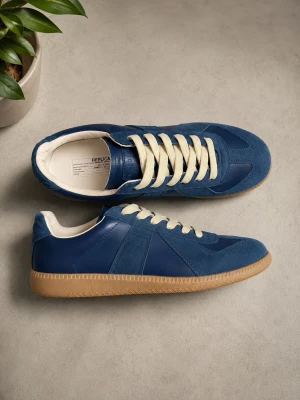 Maison margielas - Snygga blå maison marigelas med beige gummisula och vita snören. Skorna har en mix av mocka och släta paneler för en stilren look. Insidan är vit och sulan har ett klassiskt mönster för bra grepp. Perfekta för dig som gillar retrovibbar.
