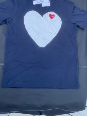 Comme de garcons t shirt - En riktigt snygg comme de garcons t shirt i toppen skick, inga skavanker alls. Alla lappar sitter på och den är som ny👍. Den är i storlek M men passar Stor S och pris kan diskuteras vid snabb affär😊