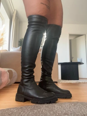 Högaboots - Höga boots från NA-KD i storlek 37. Oanvända och i mycket fint skick, men utan prislapp. Säljes då de inte kommer till användning.  Katt finns i hemmet, produkten rollas av så gott det går.