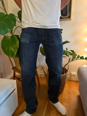 *GALET* snygga dressman jeans - Säljer ett par mörkblå jeans med rak passform och klassiska sömmar. Jeansen har fem fickor och normal midja. Perfekta till vardags för en avslappnad men snygg stil. Fina fades också. De är i storlek 33:34