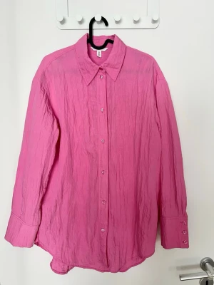 H&M Rosa krinklad skjorta - Rosa skjorta från H&M. Storlek S. Använd några gånger, något urtvättad färg men inget man direkt tänker på.