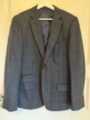 Riley Kavaj - Storlek 50 Färg - Grå, Flerfärgad, Blå Material: Yttertyg - Polyester 50%, Ull 50%  Foder - Polyester 55%, Viskos 45% Mönster - Kritstrecksrandig Tyg - Tweed Ärmlängd (cm) 63 , Axelbredd (cm) 47