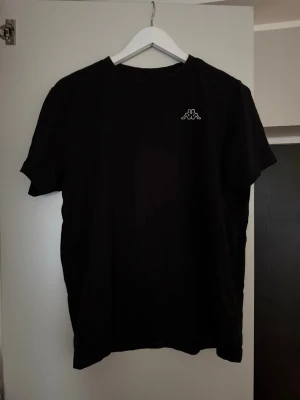 Kappa T-Shirt - Säljes då sambon ej kan ha den längre. 😊 Använd men fortfarande i superfint skick utvändigt. Enda som finns att anmärka på är att storlekslappen på insidan av nacken är sliten som syns på bild, men inget som påverkar utseendet överlag. 🌸 Utöver lappen är tröjan i jättefint skick. 😁 Skulle säga att den är normal i storlek. 