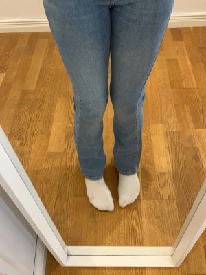 Blå bootcut jeans från Grunt - Säljer ett par blå  bootcut jeans från Grunt med gul kontrastsöm. Jeansen har utsvängda ben och är tillverkade i denim med snygg tvätt. Storlek 25