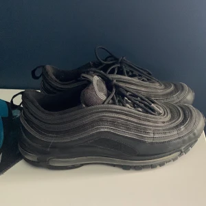 Nike air Max 97 - Hej jag säljer ett par svarta Nike air Max 97 som jag inte använt särskilt mycket men de har stått i mitt rum i ca 1 år och de är för små nu