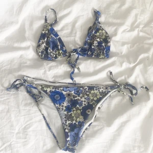 Blå och vit Blommig bikini - Så fin somrig blommig bikini. Sitter så fint, och underdelen är varken låg- eller högmidjade. Den ha både knyte på höfterna och i mitten på toppen, så fint!