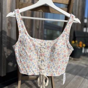 Blommigt linne med snörning. NY - Helt ny/oanvänd. Blommigt linne med snörning från Cider, mjukt och skönt material utan stretch.   Nypris 200kr