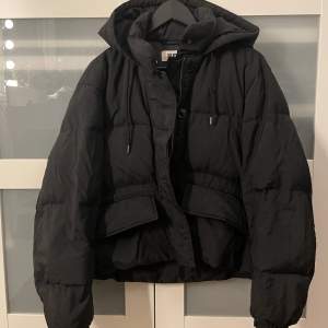 Svart pufferjacket från UniQlo!! Så varm och perfekt till vintern!  Har en luva.  Ena knappen till vänstra fickan har gått av, se tredje bilden. Finns en innerficka med dragkedja  Inköpspris: ca 2000kr  Mitt pris: 700kr  Kan förhandla pris vid snabb affär