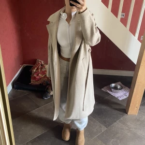 Lång kappa - Lång beige kappa från nakd. Nypris runt 800-1000. Säljs ej längre. Lite nopprig 