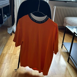 Acne studios long neck t-shirt orange - ACNE STUDIOS LOGO NECK T-SHIRT CARROT ORANGE  Använd några gånger, fin tvättad i 30C. 