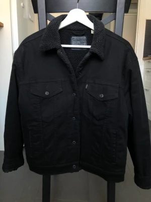Jeansjacka Levis - Svart fodrad jeansjacka från Levis. Använd men i fint skick. Strl. L.