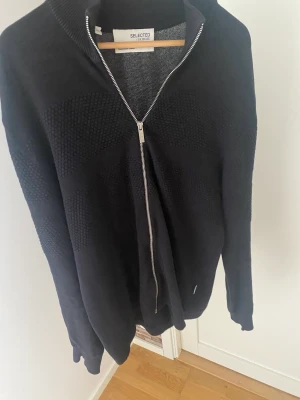 Helzip  - Tja,säljer en snygg svart helzip i skönt material. Tröjan är i storlek L och i bra skick