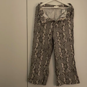 Byxor - Vida byxor i ormskinnsmönster från HM i storlek 38 och 3/4 längd. 