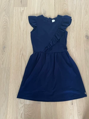 Marinblå klänning  - En jätte fin marinblå klänning med ett fantastiskt skönt tyg och den är fantastisk fin på kroppen.