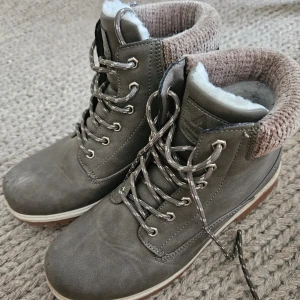 Höstskor - Mysiga och regntåliga höstskor. Använda 2-3 gånger då de inte  passade mig så bra. Tyvärr har de blivit lite slitna då de stått bland andra skor i skostället (bild 3). I övrigt i bra skick! (Skosnören, innertyg, m.m) Fluffigt teddytyg i skorna