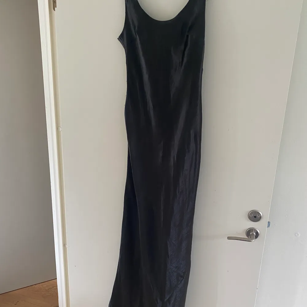 En fin klänning i blankt svart sidentyg. Den är djup i ryggen och sitter som en dröm runt kroppen! Endast använd på en finsittning så är så gott som ny. . Klänningar.