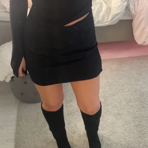 Svart kort kol - Säljer en kort svart kjol i stretchigt material från cubus, använd ett fåtal gånger. 