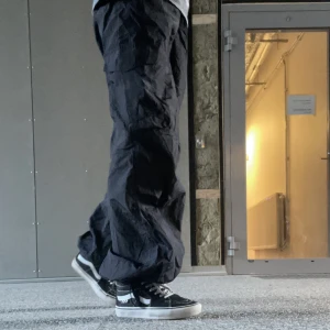 Svarta parachute pants<3 - Tjenare! Säljer dessa svarta parachute pants i nyskick då dem är lite för stora och inte kommer till användning. (Jag är 1,57) Om man vill ha fler bilder är det bara att säga till. Obs: Man kan justera nere och uppe🌊