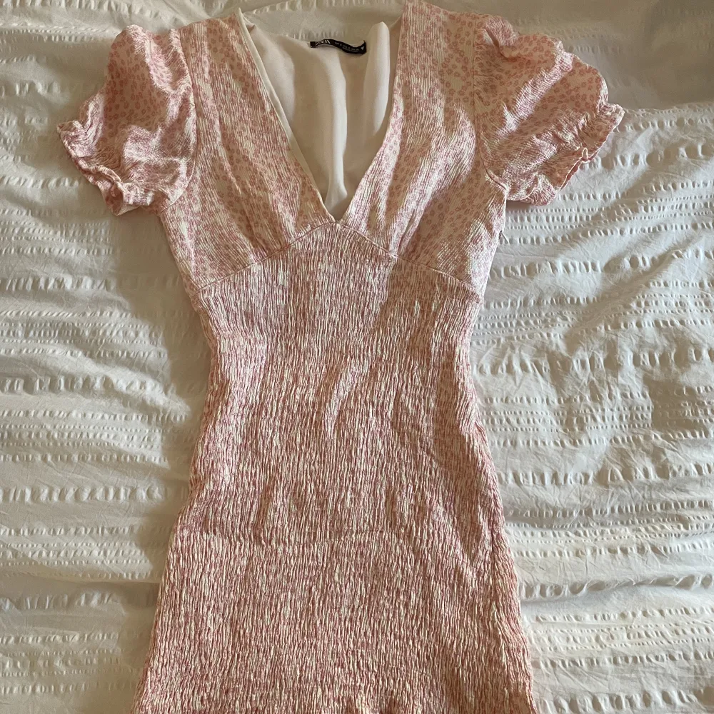 En rosa blommig klänning från zara. Köpt för ca 2 år sen men knappt kommit till användning. Orginalpris på ca 450kr. Klänningar.
