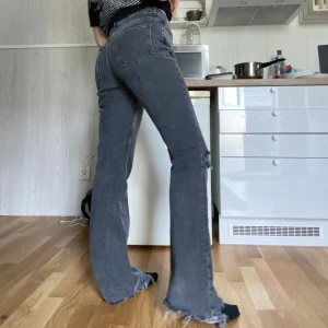 Gråa bootcut jeans med slitningar🤩 - Jag säljer dessa mörkgråa jeans med super snygga slitningar på det ena knät och längst ner🤩Jeansen är knappt använda och köptes på Gina Tricot för 599 🥰