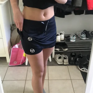 Träning shorts  - Aldrig använt. Prislapp kvar. Har bara testat. Träningsmatrial. Fina. Träningskjol med shorts under. Köpt på Sergio Tacchini. Har färgen mörkblå.