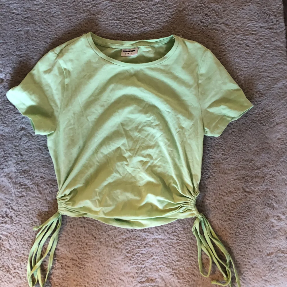 En fin mint grön t shirt med knytningar på sidorna från vero moda tror jag och är i storlek xs, använd 1 gång 💕. T-shirts.
