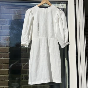 Sommar/studentklänning - Drömmig klänning med puffärmar, perfekt till studenten, skolavslutning eller sommaren. Inköpt för tre år sedan inför studenten men användes aldrig. Stl 32 från Monki med dragkedja baktill. I nyskick med prislapp kvar.