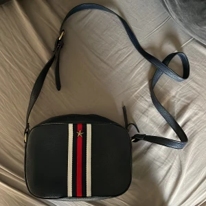 Crossbody väska  - En marinblå Tommy hilfigher inspirerad väska från Springfield (Zalando)