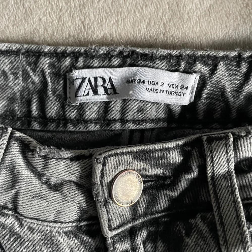 Sjukt snygga jeans från Zara storlek 34 i den perfekta gråa färgen. Hål på båda knäna och slits på insidan. Dom är lite får långa för mig (162cm). Jeans & Byxor.