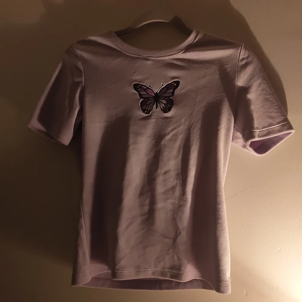 En pastellila t-shirt med en fjäril på. Så söt 🦋💜. Använd 2-3 gånger. Som ny.. Toppar.