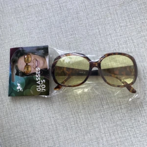 70-tala solglasögon NYA - Oöppnad förpackning och oanvända solglasögon. 70tals stil och perfekt till Halloween nu om du tänkt klä ut dig i en mer 70tals eller hippie kostym!