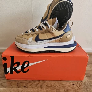 Nike sacai Vaporwaffle - Nike Vaporwaffle x Sacai Sesame blue  - Dubbel snörning och plös  - Ovandel av mesh med topplager utan sömmar  - Snörstycke och snörning fortsätter till framfoten  - Skum-stötdämpning  - Dragflik på häl för lätt på- och avtagning  - Våffelyttersula