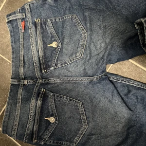 Low waist jeans  - Låga byxor med fickor där bak, passar en M. Lite slitningar längst ner på benen, annars knappt använda. Pris går o diskutera.
