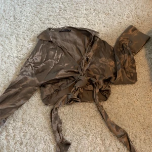 Knytakjorta - Brun kort knytskjorta i silkigt material  Använd en ggn