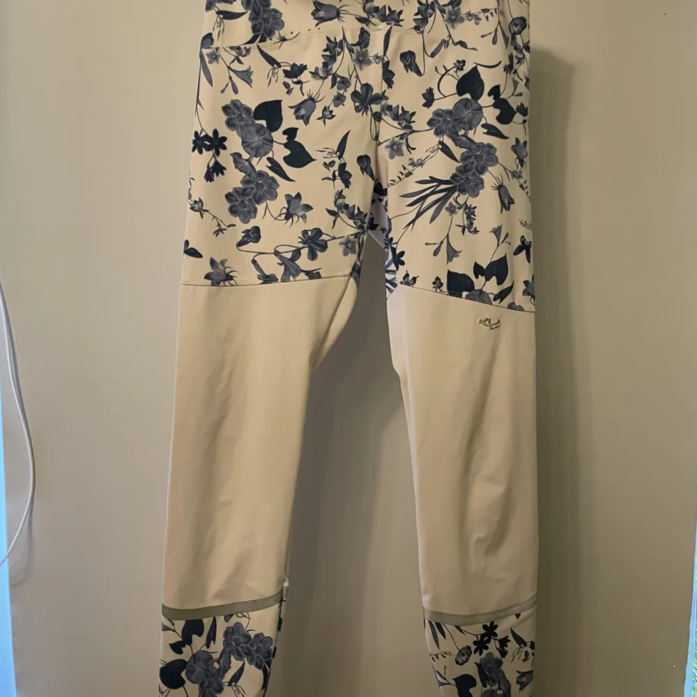 Röhnisch tröningstights, vita med blå blommor och ficka med dragkedja där bak . Jeans & Byxor.