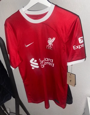 Liverpool hemmatröja 23/24 - Liverpool hemmatröja 23/24  Helt autentisk och oanvänd, köpt från unisportstore. Storlek S   Kan mötas upp i Jönköping eller så står köparen för frakten.