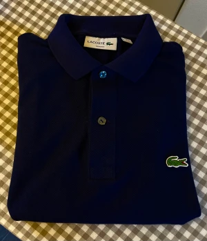 Lacoste t-shirt - Mörkblå t-shirt från Lacoste. Äkta! Slum fit, aldrig använd.