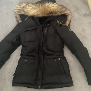 Hollies livingo jacka - Hollies livingo jacka i storlek 34/XS, använd en vinter och kommer inte användas iår för att jag har en ny, mycket bra skick och är i färgen svart, äktapäls. Pris kan diskuteras 