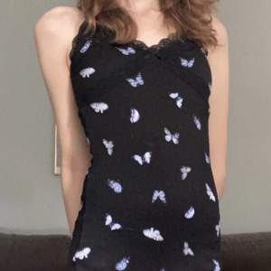 Svart tight klänning från H&M med blåa fjärilar!🦋Använd ca 5 ggr, väldigt fint skick!💙 Säljer denna klänning då den inte är min stil längre. Storlek XS✨