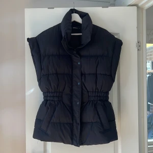 Gina Tricot Väst - Storlek: S Lola Puffer Vest  Supersnygg väst perfekt till alla årstider! ❄️🌺🌞🍂 Två fickor, dragkedja döljs under knappar, hög krage, intagen midja.  Sparsamt använd. I fint skick utan anmärkning. Nypris: 600kr, mitt pris 450kr. Pris kan diskuteras ✨