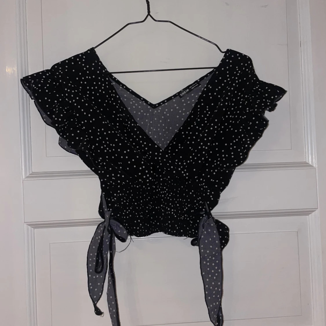 Svart topp med rosetter i midjan