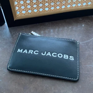 Marc Jacobs Plånbok - Så nice plånbok från Marc Jacobs🤍 Fack med dragkedja där man får plats med allt från kort till kvitton och allt man behöver. Där sitter också en nyckelhållare! På utsidan är det 3 tack för kort där man får plats med 6kort! Nypris 1999kr🤍