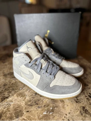Jordan 1 Mid coconut milk particle grey - Säljer mina Jordan 1 Mid coconut milk particle grey då dom inte kommer till användning. Dom är köpta sommaren 2022 och är i storlek 44. Skicket på skorna är fint utan märkbart slitage. Kartong, kvitto och snören medföljer!