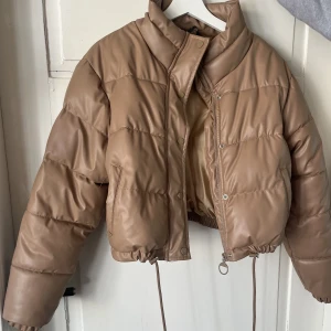 Pufferjacka - Säljer denna snygga jacka i fake läder. Super snygg och skön till vinter/höst. Använd några gånger men är som ny. Har justerbara band i midjan. Pris kan diskuteras ❣️❣️