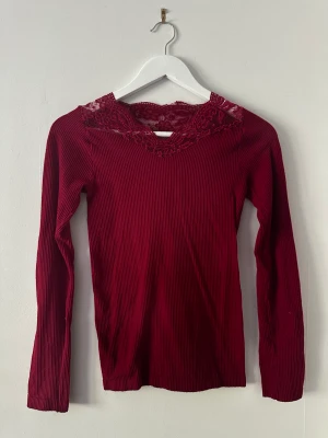 Vinröd topp med spetts  - Vinröd ribbad tröja i storlek S/M. Fint skick. Kan mötas upp i Göteborg/Mölndals området eller frakta. Frakten står man för själv 🥰