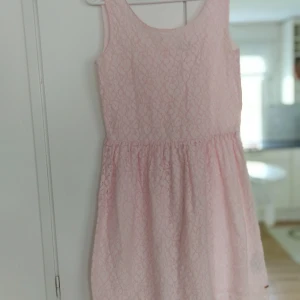 Klänning  - Fin ljusrosa sommarklänning med spetsmönster i nyskick. Kofta ingår i priset.