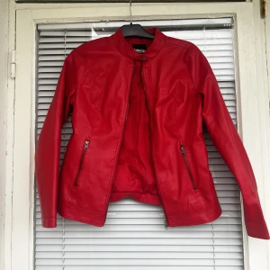 Vintage läderjacka skinnjacka leatherjacket bikerjacka motorcykeljacka läder leather jacka jacket läderimitation vegan faux leather fejkläder vegan - Läderjacka (läderimitation) i fantastisk röd färg säljes. Upplevs som en strl: S/M. Jackan behöver vädras lite pga källarlukt, därav det extremt låga priset. 